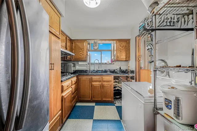 a kitchen with granite countertop a refrigerator stove and sink