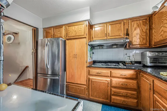 a kitchen with stainless steel appliances a refrigerator and a stove top oven