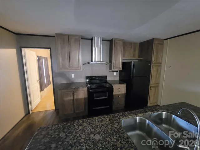 a kitchen with a sink a refrigerator and a stove top oven