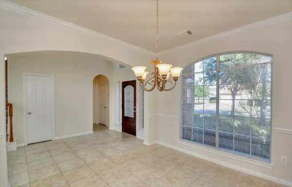 a view of a room with large windows chandeliers and kitchen view