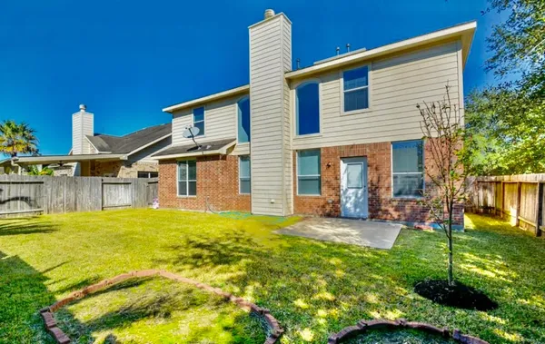 a backyard of a house with table and chairs plants and large trees