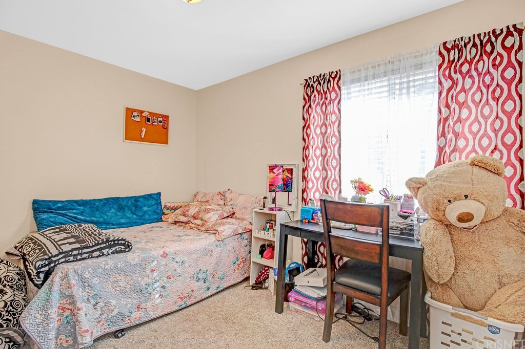13666 Pinney Street Pacoima, CA 91331 - Photo 19 of 34 a bedroom with a bed and a table in it