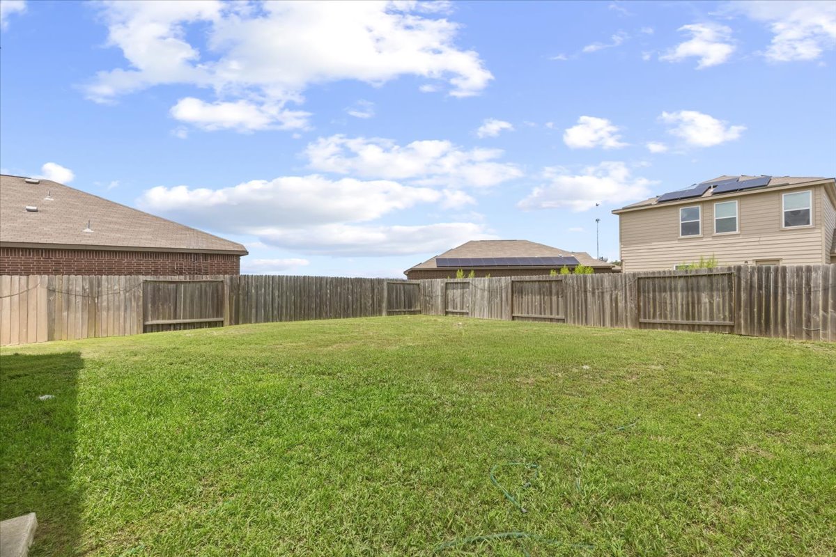 19808 Hubert R Humphrey Road Manor, TX 78653 - Photo 8 of 37 A spacious, verdant yard with fencing offers ample outdoor living potential.