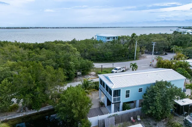 an aerial view of a house with a yard and lake view