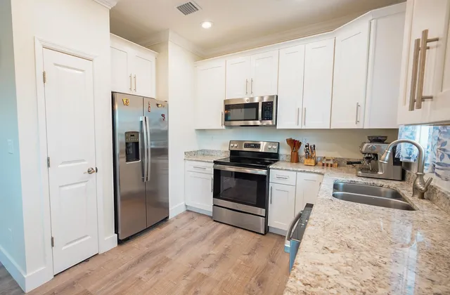 a kitchen with stainless steel appliances granite countertop a refrigerator stove and sink