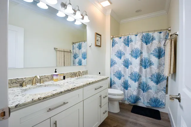 a bathroom with a granite countertop sink a toilet and a mirror