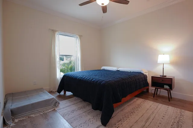 a bedroom with a bed lamps and wooden floor