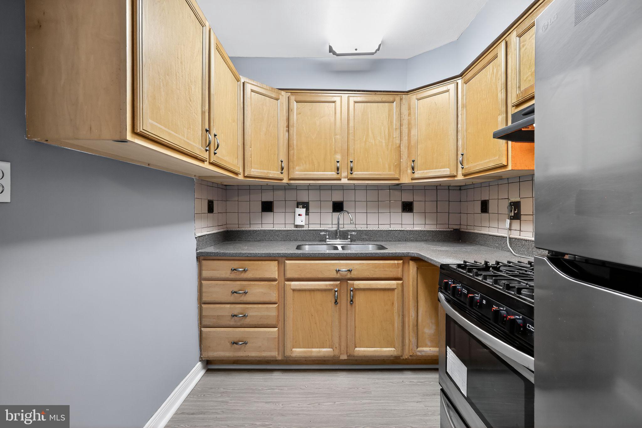 1621 Addison Road South District Heights, MD 20747 - Photo 2 of 15 a kitchen with stainless steel appliances granite countertop a sink and a stove