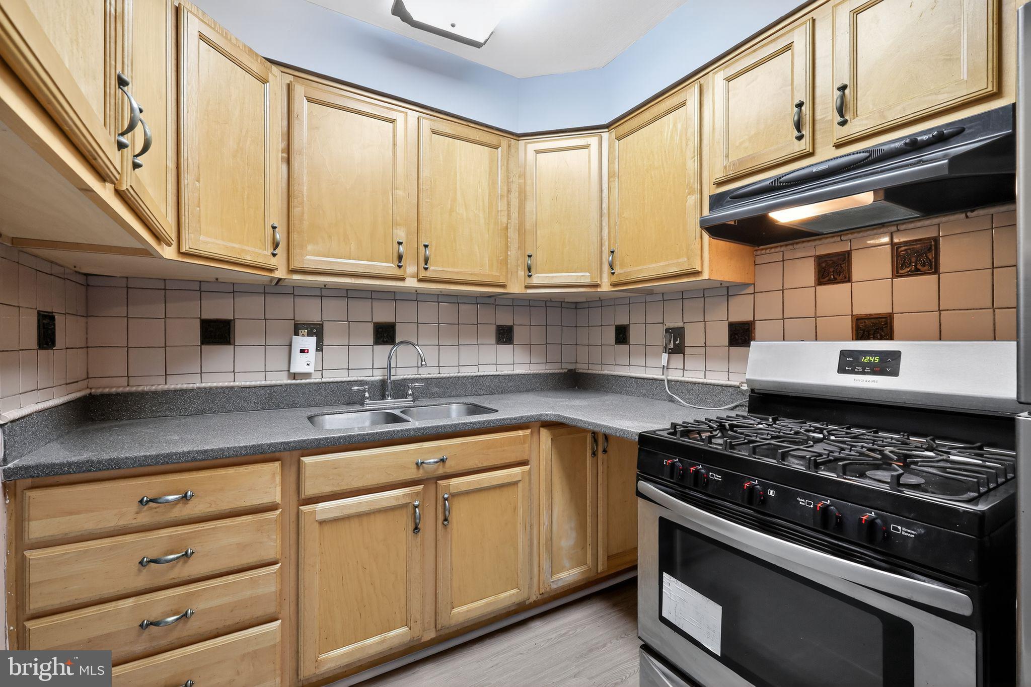 1621 Addison Road South District Heights, MD 20747 - Photo 3 of 15 a kitchen with granite countertop a stove and a sink