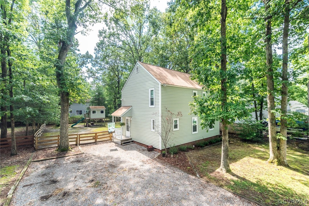 a view of backyard with a wooden fence and large trees