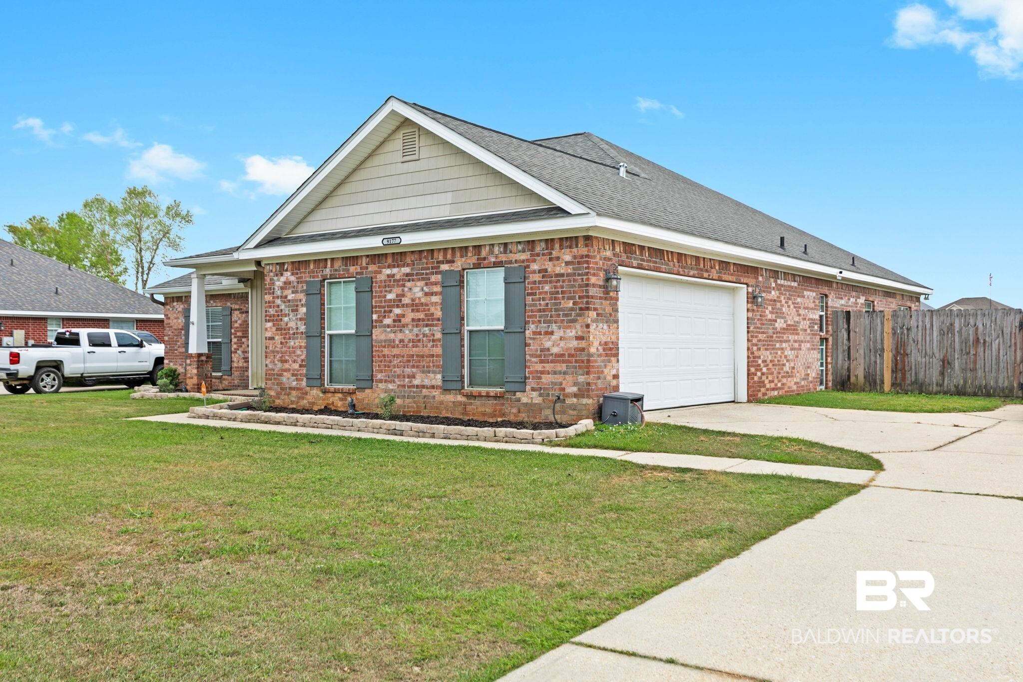 9177 Labrador Trail Theodore, AL 36582 - Photo 2 of 24 View of home's exterior featuring concrete driveway, a garage, brick siding, and a shingled roof