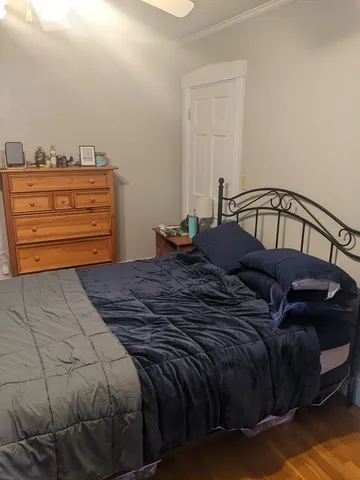 a bed sitting in a bedroom next to a window with dresser