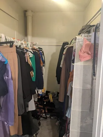 a view of walk in closet with clothes and shoes