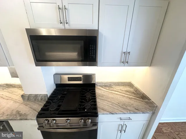 a stove top oven sitting inside of a kitchen