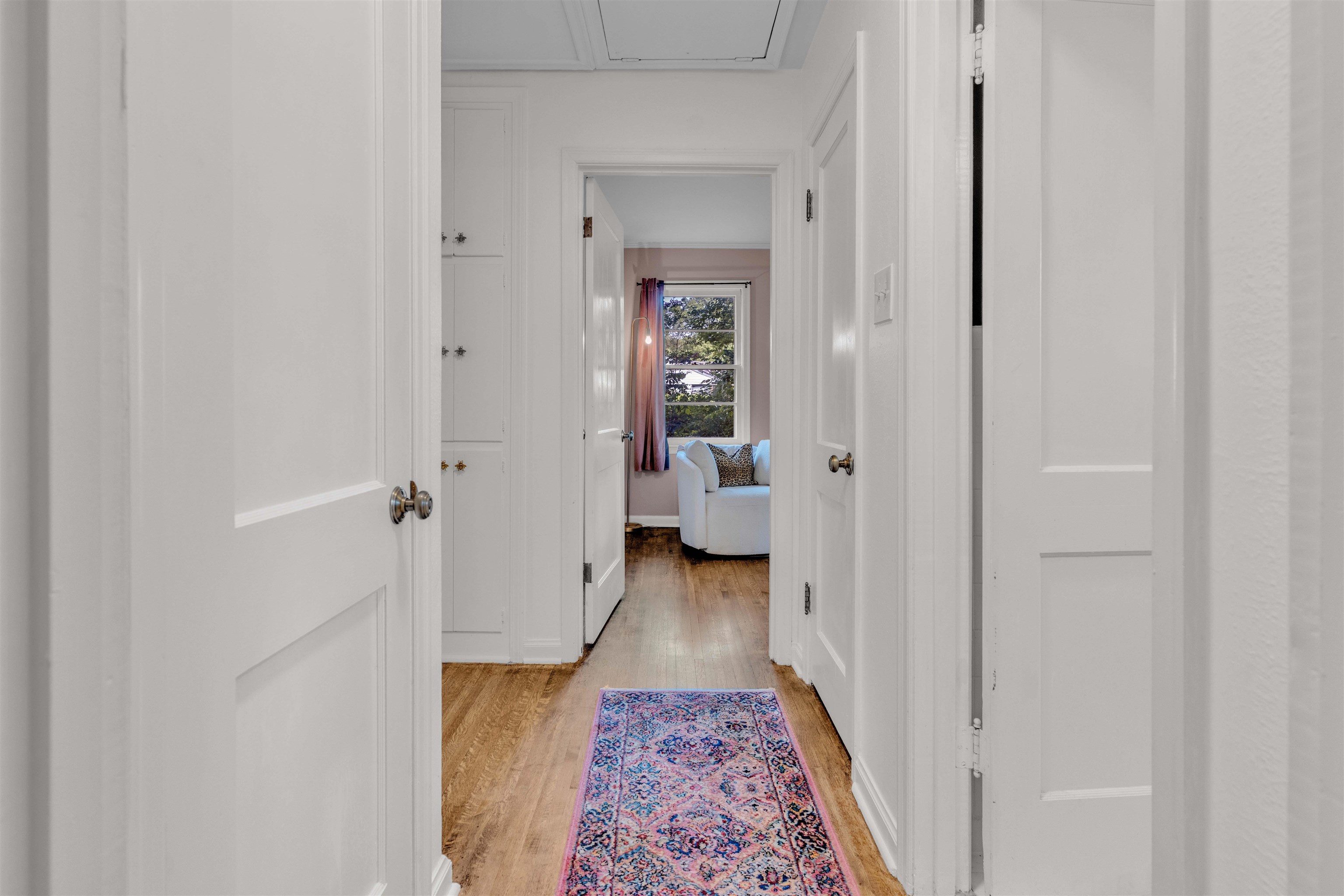 4564 Verne Road Memphis, TN 38117 - Photo 10 of 25 Hallway featuring wood-finish flooring, white paneled doors, and built-in cabinetry