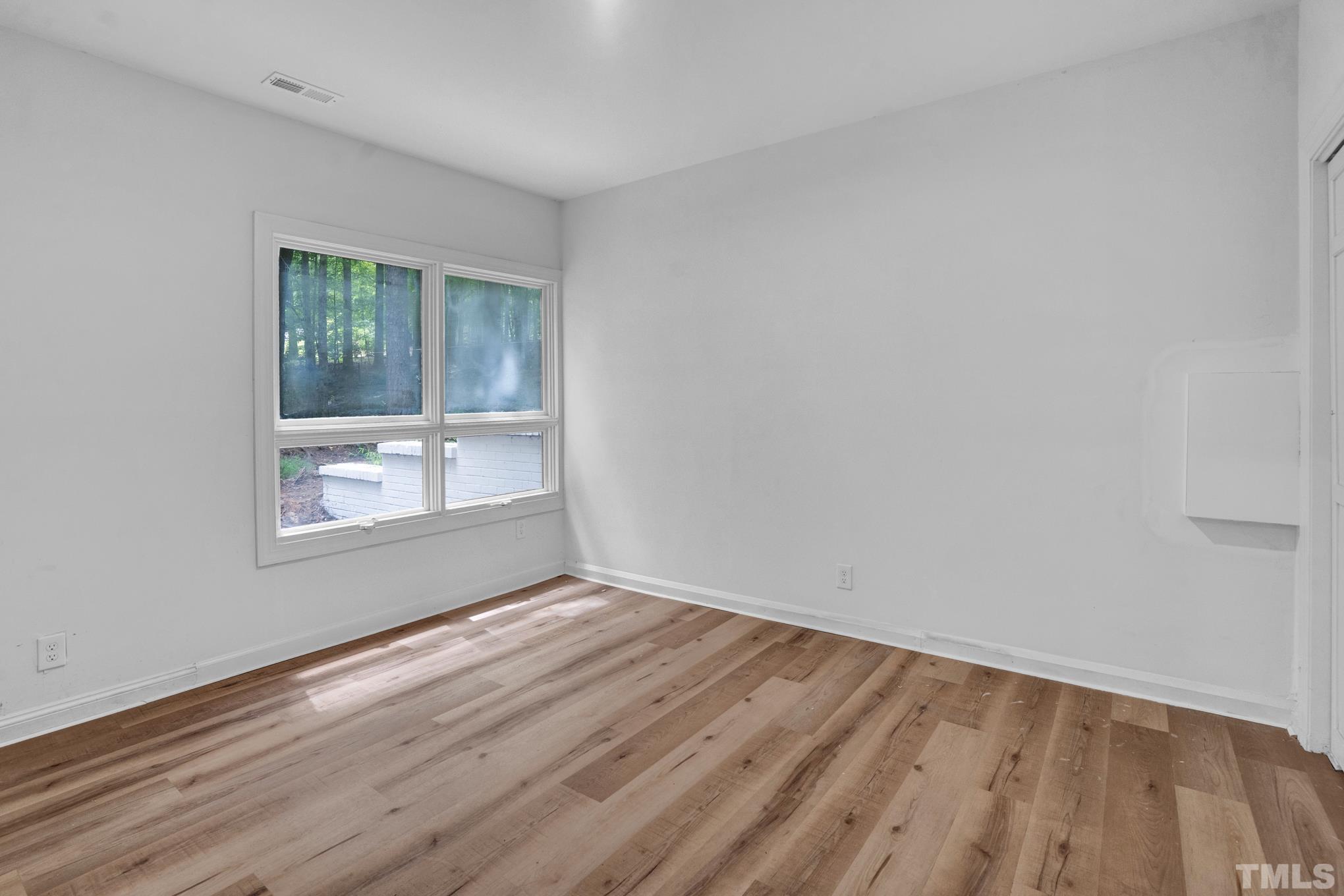 12600 Old Creedmoor Road Raleigh, NC 27613 - Photo 7 of 24 a view of an empty room with wooden floor and a window