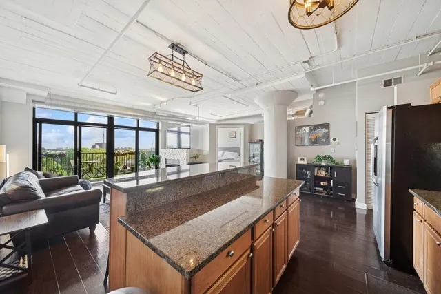 a kitchen with a table chairs refrigerator and wooden floor