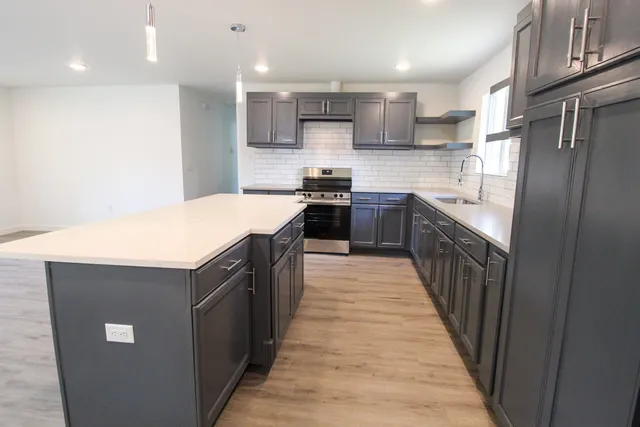 a kitchen with stainless steel appliances granite countertop a stove top oven a sink and dishwasher