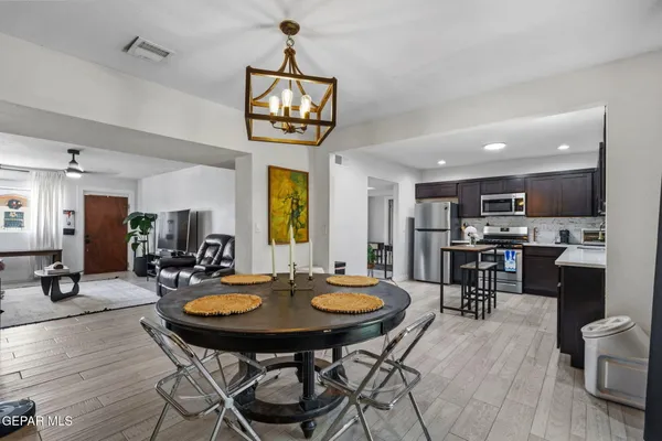 a view of a dining room and livingroom with furniture wooden floor a chandelier