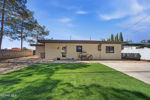 a view of a house with backyard and sitting area