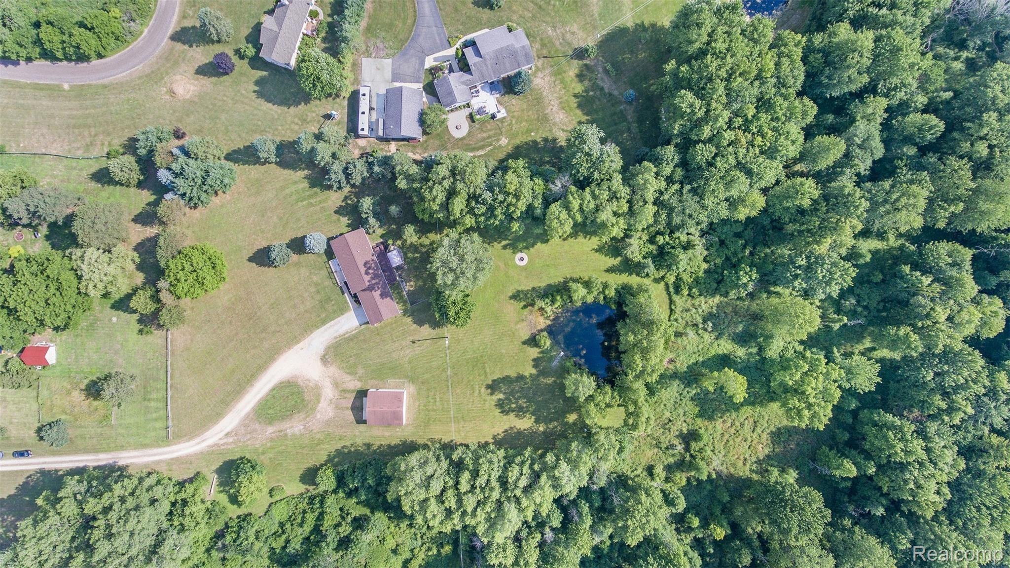 6671 North Fowlerville Road Fowlerville, MI 48836 - Photo 3 of 27 Overhead aerial view of home, woods and pond