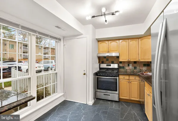 a kitchen with a sink appliances cabinets and a large window