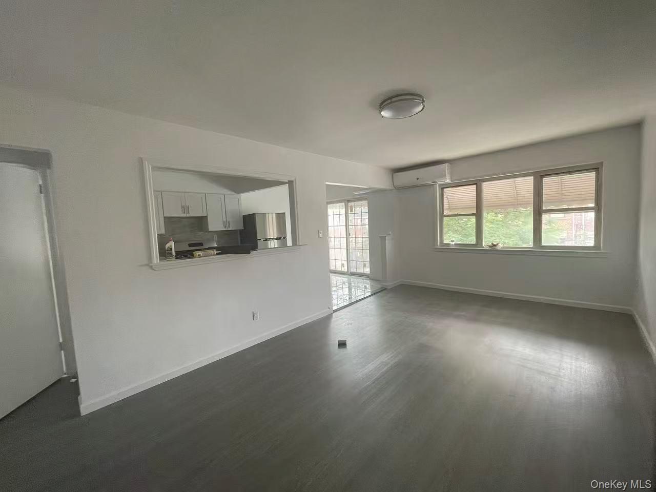 30-47 71st Street Queens, NY 11370 - Photo 3 of 8 an empty room with wooden floor and windows
