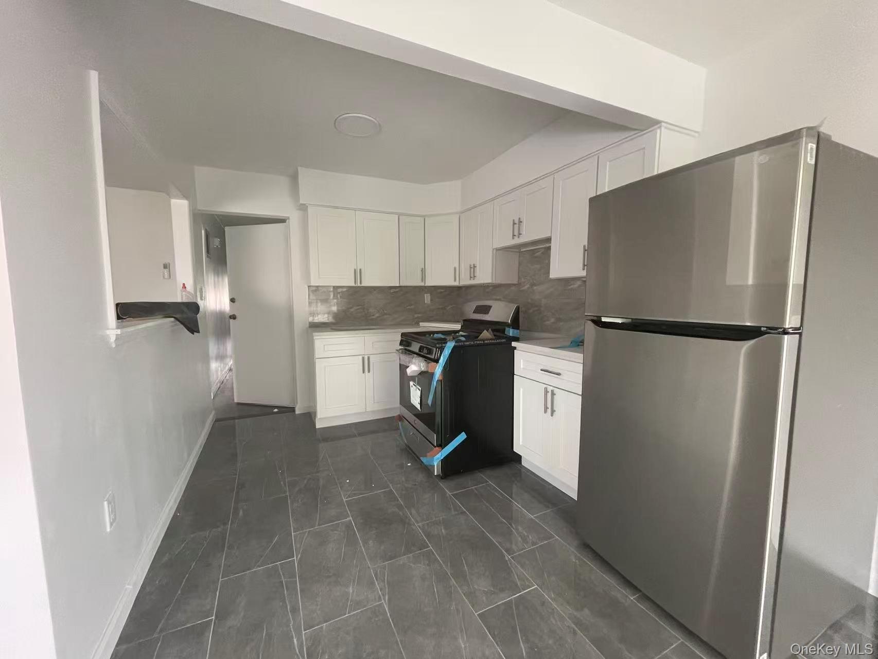 30-47 71st Street Queens, NY 11370 - Photo 4 of 8 a kitchen with stainless steel appliances a refrigerator sink and cabinets