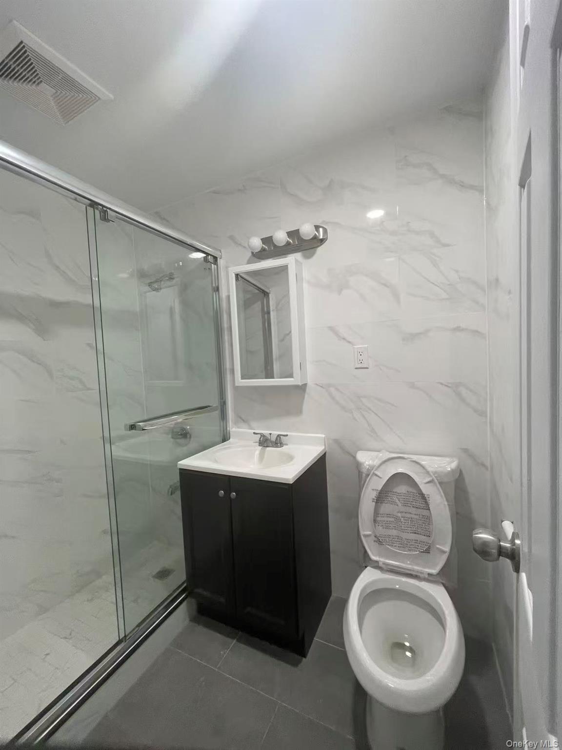 30-47 71st Street Queens, NY 11370 - Photo 6 of 8 a bathroom with a toilet sink and mirror