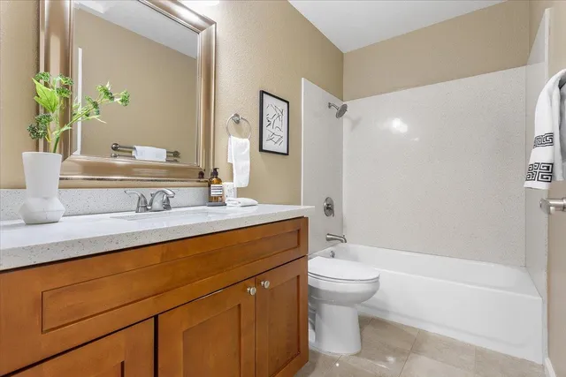 a bathroom with a granite countertop sink a toilet and a bathtub