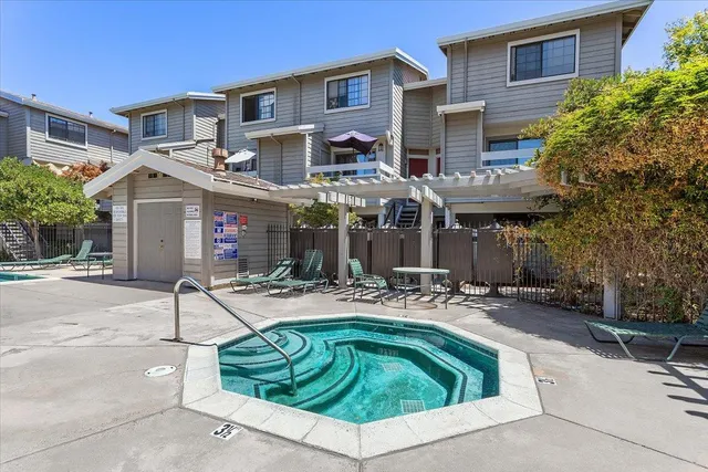 a view of a brick building with a small yard and a car parked in front of it