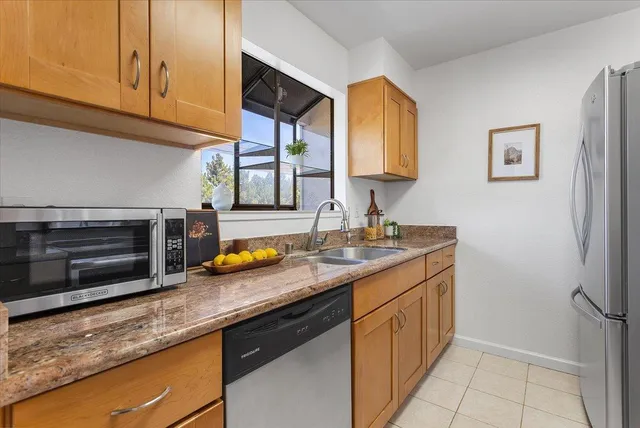 a kitchen with stainless steel appliances granite countertop a sink stove and cabinets