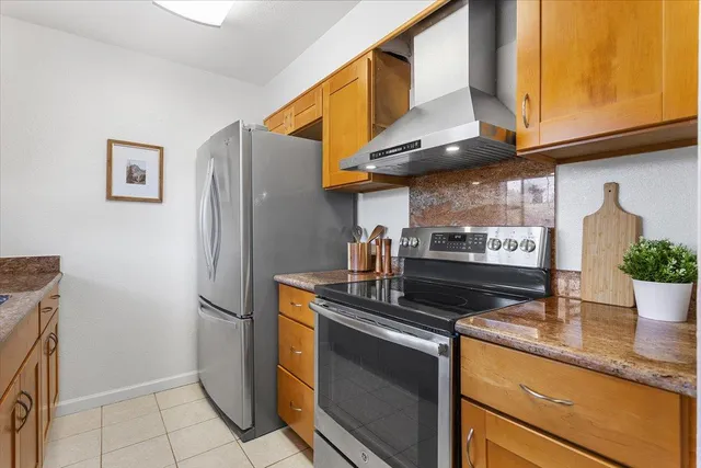 a kitchen with stainless steel appliances granite countertop a sink a stove and a refrigerator