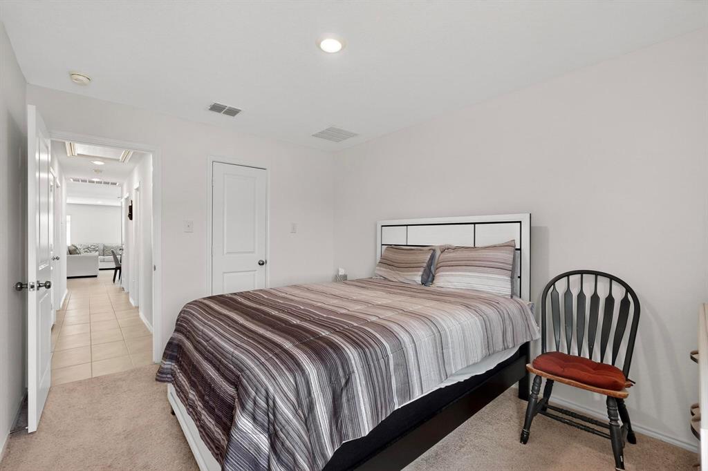 154 Herman Lane Princeton, TX 75407 - Photo 16 of 37 a bedroom with a bed a mirror and a chair