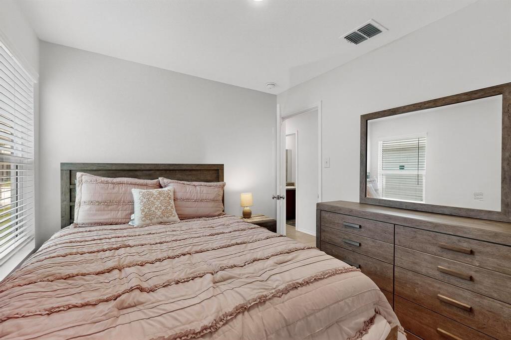 154 Herman Lane Princeton, TX 75407 - Photo 20 of 37 a bedroom with a bed and a mirror on dresser
