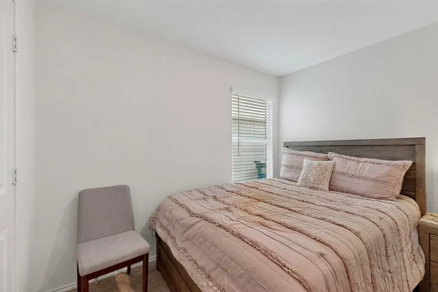 a bedroom with a bed and a mirror on dresser