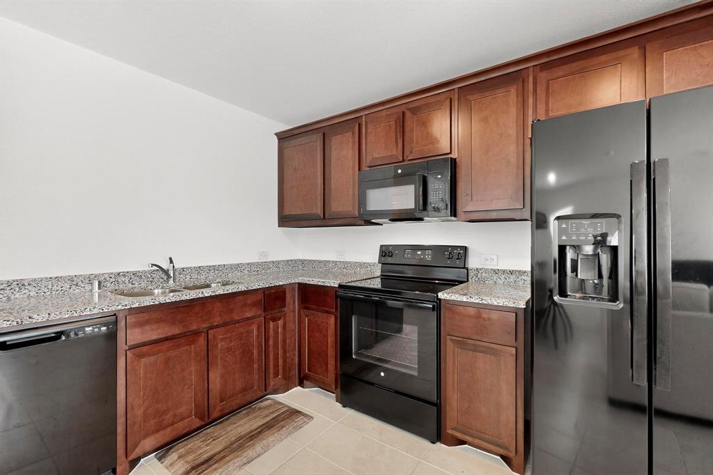 154 Herman Lane Princeton, TX 75407 - Photo 5 of 37 a kitchen with stainless steel appliances granite countertop a sink stove and refrigerator