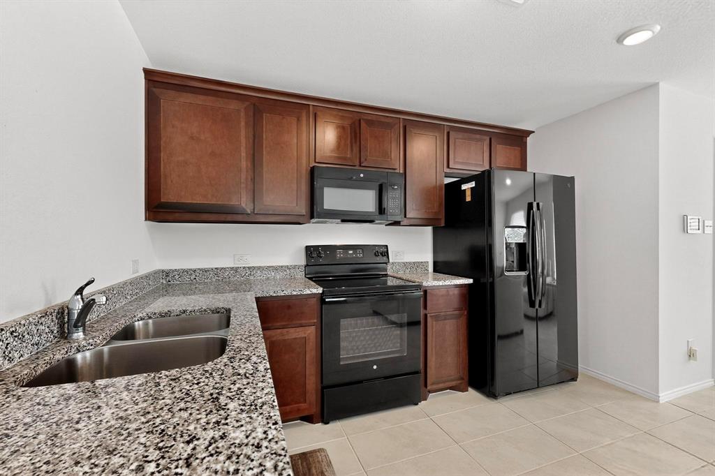 154 Herman Lane Princeton, TX 75407 - Photo 6 of 37 a kitchen with stainless steel appliances granite countertop a refrigerator stove and sink