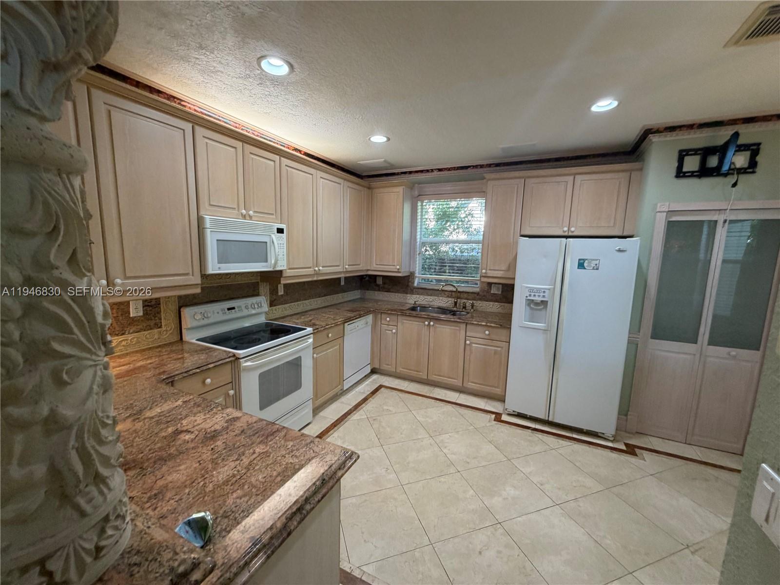 6601 Southwest 166th Court Miami, FL 33193 - Photo 7 of 28 a kitchen with a sink a counter top space cabinets and stainless steel appliances