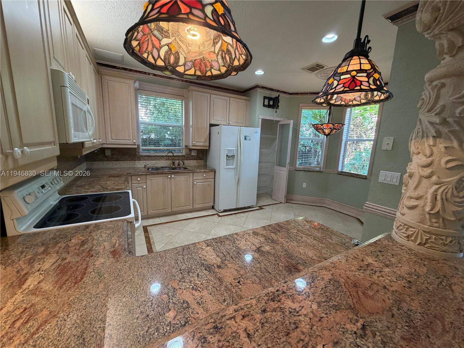 6601 Southwest 166th Court Miami, FL 33193 - Photo 9 of 28 a kitchen with stainless steel appliances granite countertop a stove a sink and a microwave