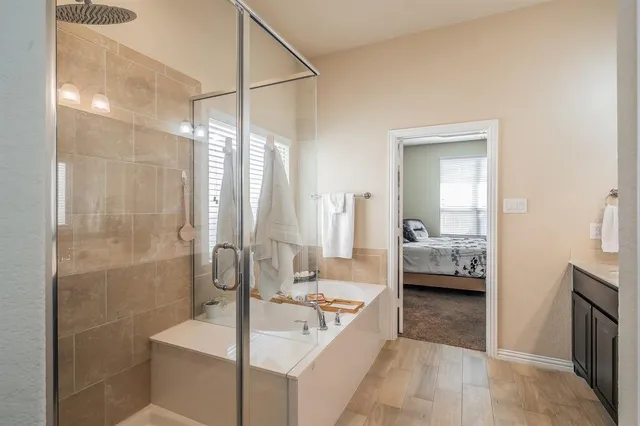 a en suite spacious bathroom with a tub shower and bedroom view