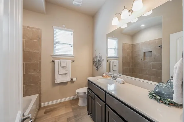 a bathroom with a sink a toilet a large mirror and shower