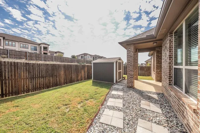 a view of backyard with large trees and wooden fence