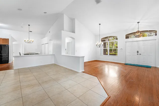 an empty room with windows and chandelier
