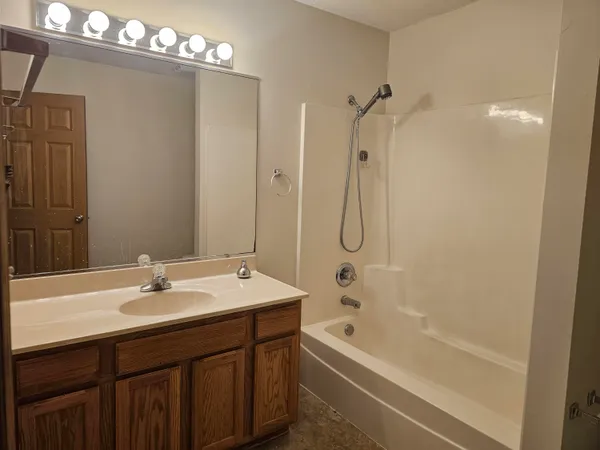 a bathroom with a sink vanity tub and shower