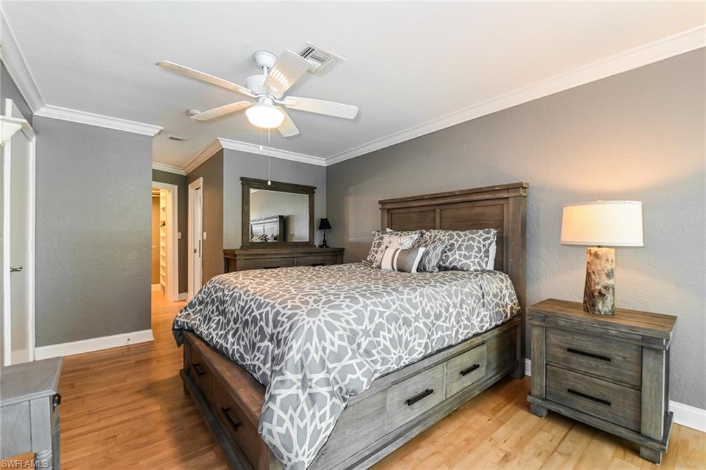 283 Forest Hills Boulevard Naples, FL 34113 - Photo 7 of 11 Bedroom with ornamental molding, light wood-style flooring, ceiling fan, a closet, and a textured wall