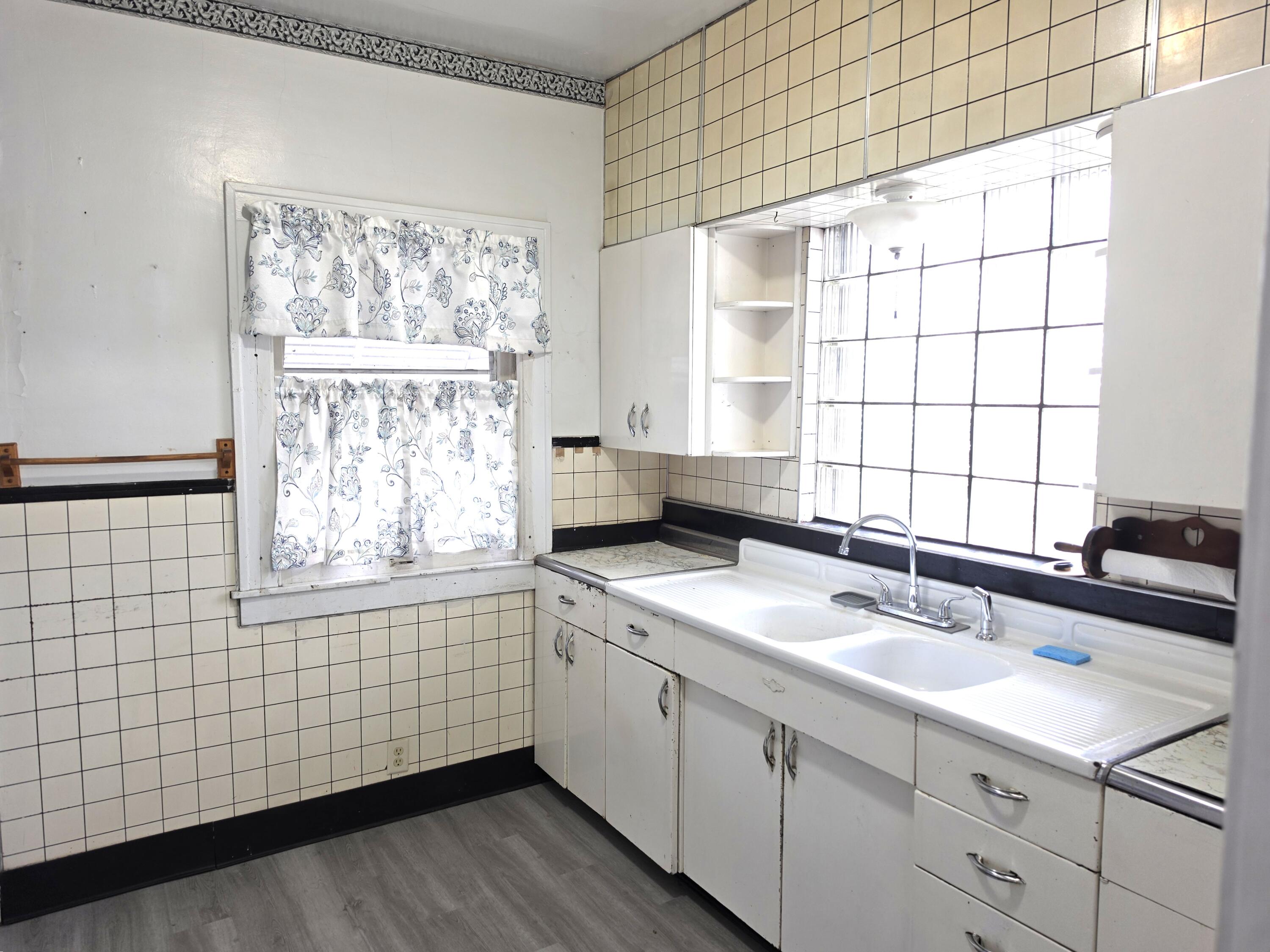 1173 Tyler Street Gary, IN 46407 - Photo 12 of 36 a kitchen with a sink window and cabinets