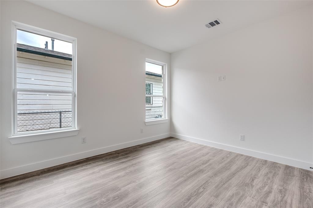 4812 Fellows Lane Dallas, TX 75216 - Photo 22 of 25 an empty room with wooden floor and windows