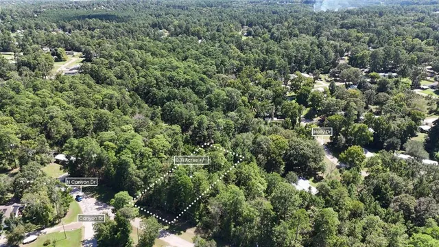 an aerial view of residential house with outdoor space and trees all around