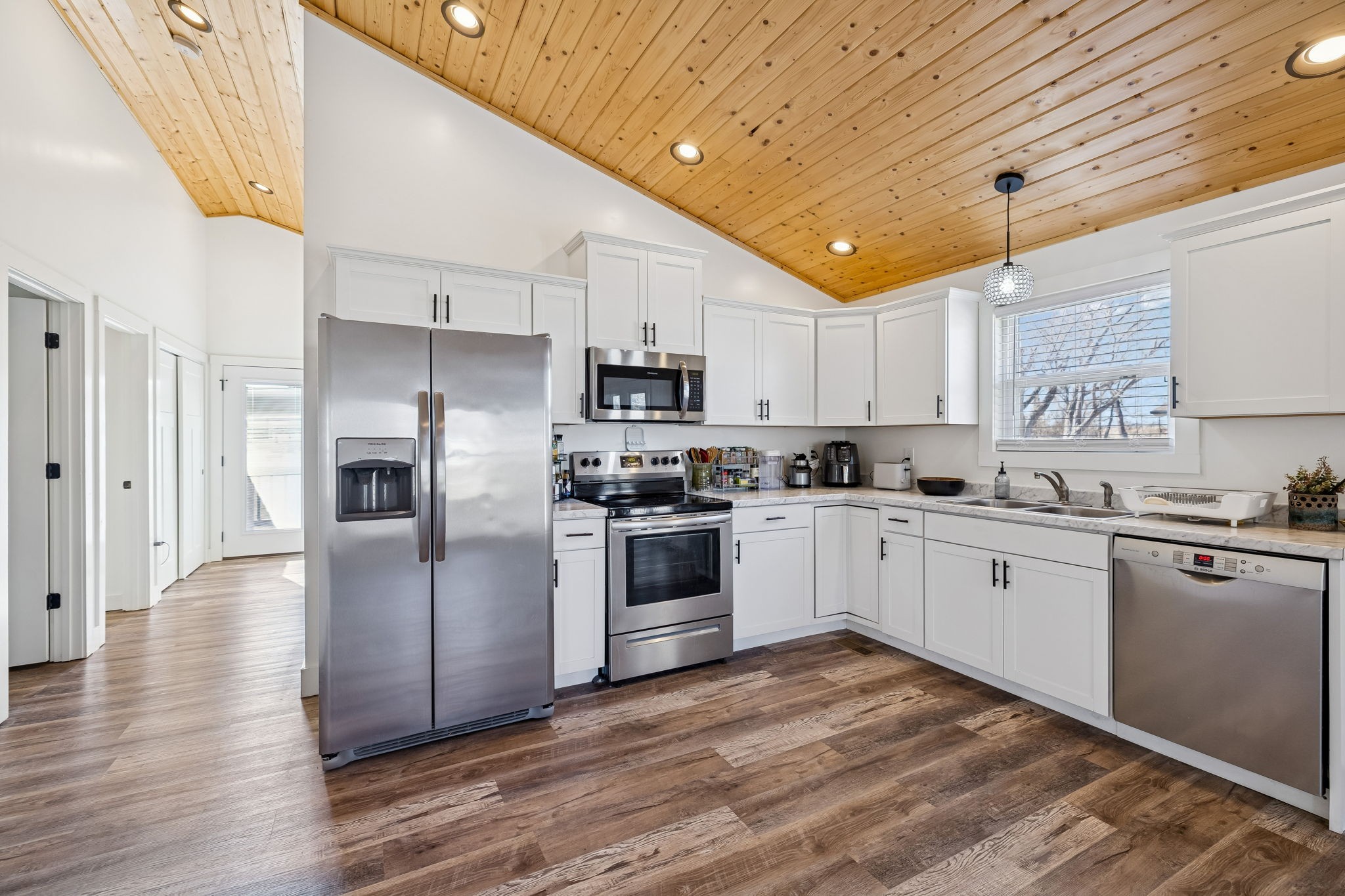 516 Davis Street Cowan, TN 37318 - Photo 12 of 40 a kitchen with stainless steel appliances granite countertop a refrigerator a sink dishwasher a stove and white cabinets with wooden floor